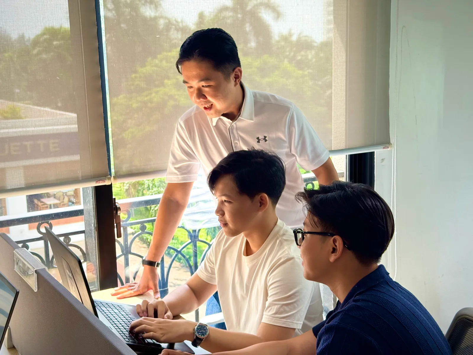 FIX Partner developers collaborating around a laptop in Ho Chi Minh City